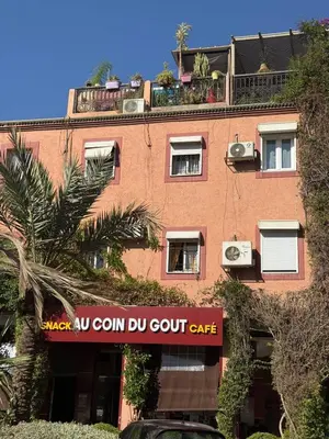 a tall brick building with a sign that reads au corn du court cafe at RIAD SAAD Marrakech in Marrakech