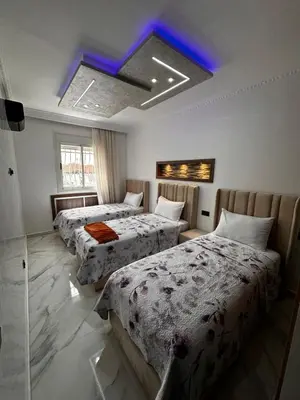 a hotel room with three beds and a blue ceiling at Appartement Familial Spacieux & Moderne - Confort et Style au Rendez-vous ! in Marrakech