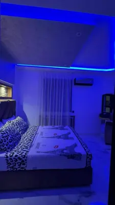 a bedroom with a bed with a blue lighting at Appartement Familial Spacieux & Moderne - Confort et Style au Rendez-vous ! in Marrakech