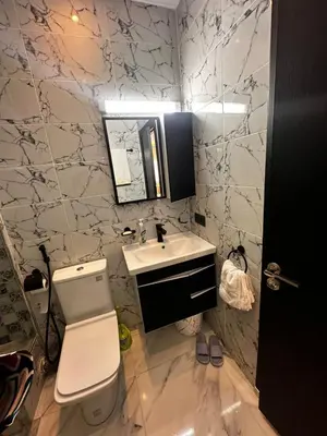 a bathroom with a white toilet and a sink at Appartement Familial Spacieux & Moderne - Confort et Style au Rendez-vous ! in Marrakech