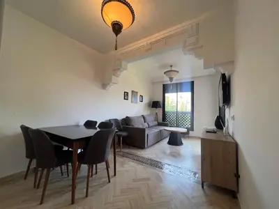 a living room with a table and a couch at L'oasis d'Atlas Golf Resort in Marrakech