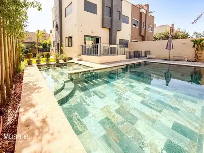 a swimming pool in front of a building at Villa 5 chambres targa in Marrakech