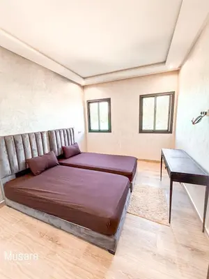 a bedroom with a large bed and a desk at Villa 5 chambres targa in Marrakech