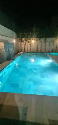 a large blue swimming pool at night at Villa 5 chambres targa in Marrakech