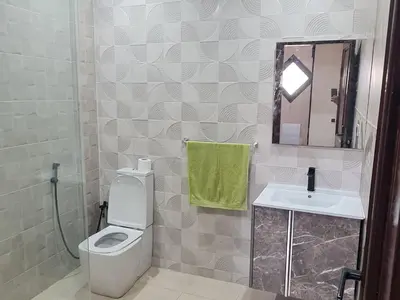 a bathroom with a toilet and a sink and a mirror at Villa 5 chambres targa in Marrakech