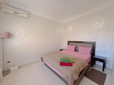 a bedroom with a bed with pink sheets and pink pillows at Studio Confort au Cœur de Guéliz proche Carré Eden in Marrakech