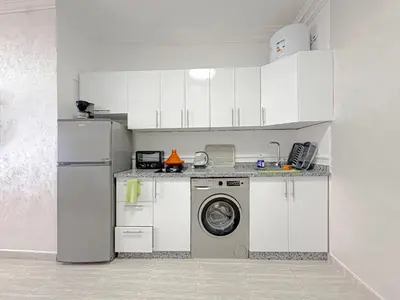 a white kitchen with a washing machine and a washer at Studio Confort au Cœur de Guéliz proche Carré Eden in Marrakech