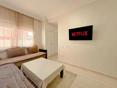 a living room with ametix sign on the wall at Studio Confort au Cœur de Guéliz proche Carré Eden in Marrakech