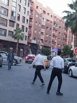 a group of men dancing in a street with cars at Studio Confort au Cœur de Guéliz proche Carré Eden in Marrakech