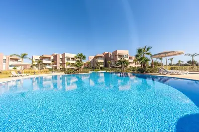 a large swimming pool in front of some apartments at Vue Piscine et Golf Luxueux rez de jardin in Marrakech