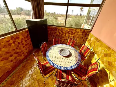 a table and chairs in a room with a window at la palmeraie village 3 in Marrakech