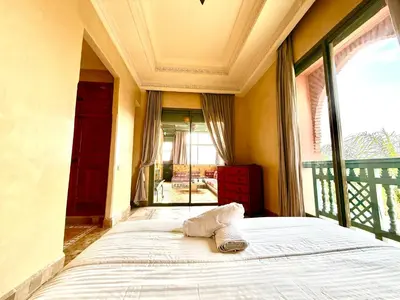 a bed in a room with a large window at la palmeraie village 3 in Marrakech
