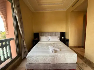 a bedroom with a bed and a large window at la palmeraie village 3 in Marrakech