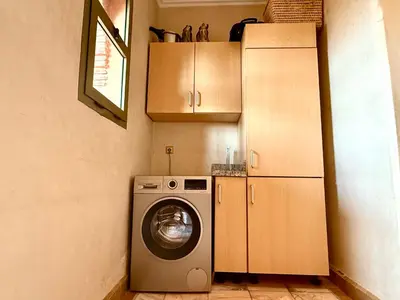 a kitchen with a washing machine and a refrigerator at la palmeraie village 3 in Marrakech
