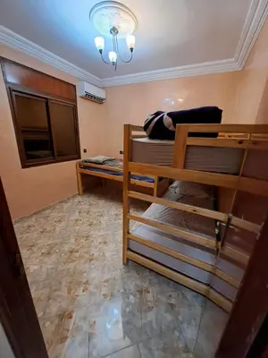 a room with two bunk beds and a chandelier at Sweet home in Marrakech