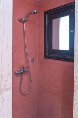 a shower in a red wall with a window at Agdal Prestige in Marrakech