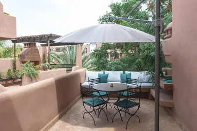 a table and chairs under an umbrella on a patio at Agdal Prestige in Marrakech