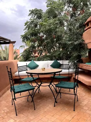 a table and two chairs and a table and a tree at Agdal Prestige in Marrakech