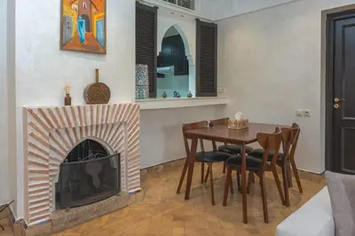 a living room with a table and a fireplace at Agdal Prestige in Marrakech