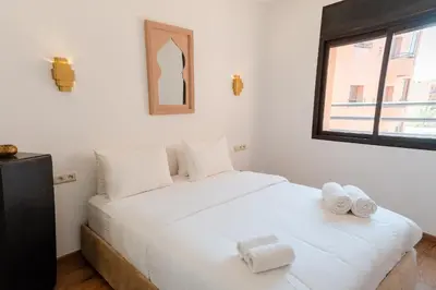 a bedroom with a white bed with towels on it at Refuge blanc terrasse priveee a cite de Majorelle in Marrakech