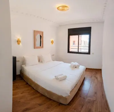 a bedroom with a large bed with white sheets at Refuge blanc terrasse priveee a cite de Majorelle in Marrakech