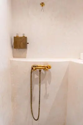 a bathroom with a gold hose hooked up to a sink at Refuge blanc terrasse priveee a cite de Majorelle in Marrakech