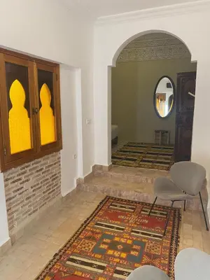 a living room with a table and chairs and a rug at Riad khalid zrika in Marrakech