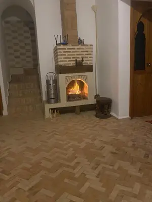 a fireplace in a living room with a fire place at Riad khalid zrika in Marrakech