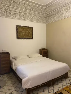 a bedroom with a bed and a painting on the wall at Riad khalid zrika in Marrakech