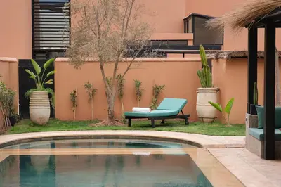 a pool in a yard with a bench and a chair at Riad Beldi Chic Golf Al Maaden in Marrakech