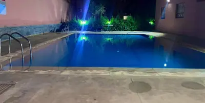 a swimming pool at night with lights in it at Appartement Luxueux à Guéliz in Marrakech