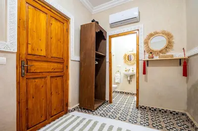 a bathroom with a wooden door and a sink at Riad Ryme-Newly renovated-Exclusive-Free breakfast in Marrakech