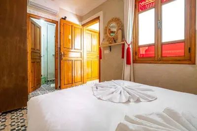 a bedroom with a white bed in a room with windows at Riad Ryme-Newly renovated-Exclusive-Free breakfast in Marrakech