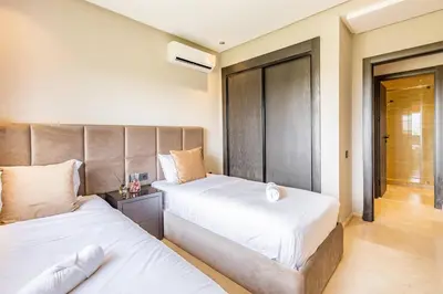 two beds in a small room with at Opulent 3BR apartment, pool view in Marrakech