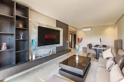 a living room with a couch and a tv at Opulent 3BR apartment, pool view in Marrakech