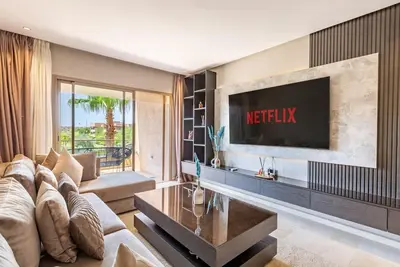 a living room with a couch and a tv at Opulent 3BR apartment, pool view in Marrakech