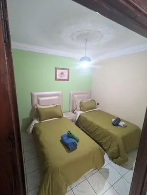 two beds in a room with green walls at riad rabiaa in Marrakech