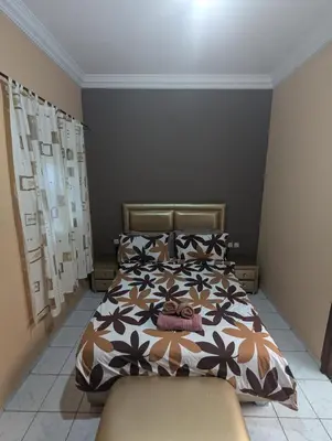 a bedroom with a bed with a brown and white comforter at riad rabiaa in Marrakech