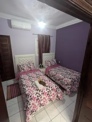 a bedroom with two beds with a cat on them at riad rabiaa in Marrakech