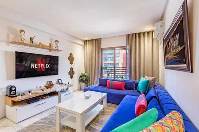 a living room with a blue couch and a tv at AkHouse PB15 Fully Equipped - Guéliz TOP Center in Marrakech