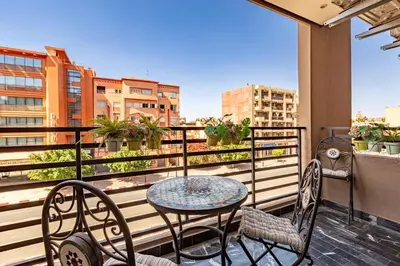 a table and chairs on a balcony with a view at AkHouse PB15 Fully Equipped - Guéliz TOP Center in Marrakech