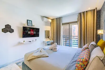 a bedroom with a large bed and a tv at AkHouse PB15 Fully Equipped - Guéliz TOP Center in Marrakech