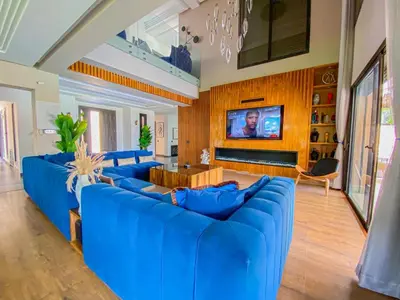 a large living room with blue couches and a tv at villas route d amzmiz in Marrakech