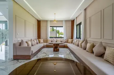 a living room with a long couch and a table at Villa Arbia - Piscine - 5BDR - Fitness - Ping-Pong in Sraghna