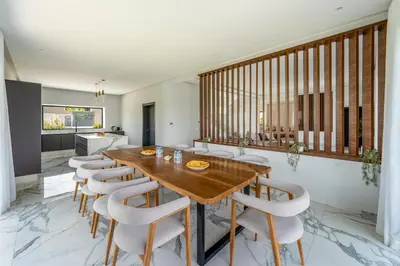 a dining room with a wooden table and chairs at Villa Arbia - Piscine - 5BDR - Fitness - Ping-Pong in Sraghna