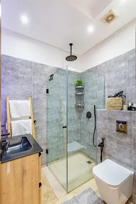 a bathroom with a shower and a toilet and a sink at Modern Apartment Gueliz City Center in Marrakech