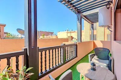 a patio with a table and chairs on a balcony at Stylish Apartment with Terrace Central Marrakech in Marrakech