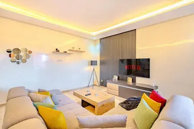 a living room with a couch and a tv at Stylish Apartment with Terrace Central Marrakech in Marrakech