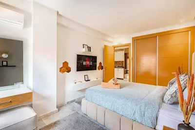 a bedroom with a large bed and a television at PB16 Flat Fully Equipped Guéliz TOP Center in Marrakech