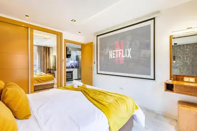 a bedroom with a bed and a tv on the wall at Luxury CINÉMA-BEDROOM AK04 Guéliz-TopCenter in Marrakech